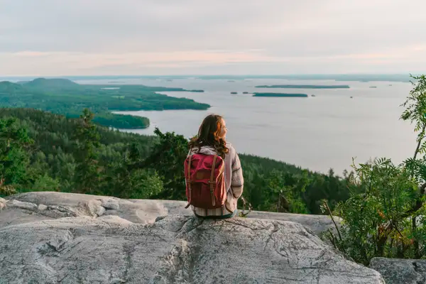 Mulher desfrutando de linda vista para lago da Finlândia, o país mais feliz do mundo