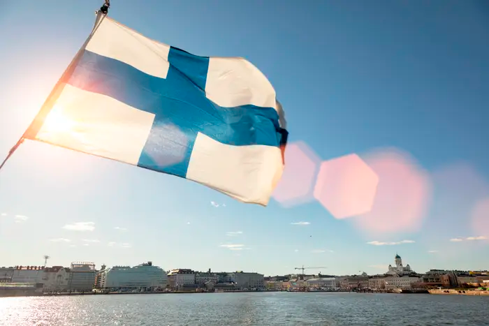 Bandeira da Finlândia com vista de fundo para o local, o país mais feliz do mundo